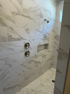 a bathroom with white marble walls and floor