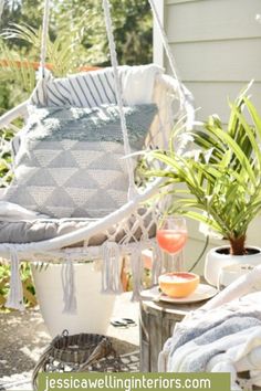 a hammock chair sitting on top of a patio next to a potted plant