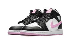 a pair of black and white sneakers with pink accents on the upper half of the shoe