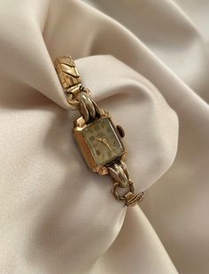 Vintage 1940s Art Deco 15 Jewels Rolled Gold Plated Rectangular Dial With Stretchy Bracelet Strap Wind Up Cocktail Wristwatch By Avia A unique vintage lovely item in excellent vintage condition considering age  There is some very light age related gold fading on the bezel, which is to be expected with a near antique item (shows up as slightly more of a silver undertone) This beautiful watch has some slight age related patina/ discolouration on the dial. (see images) This just adds to the vintage charm! stainless steel back  The acrylic curved lens is in good condition , the dial has risen gold plated hour markers and gold hands.    A very unique, elegant,  classy wristwatch.  Measurements-  Stretchy strap (unstretched 16cm)  Keeping time (service history unknown) Models wrist size is 15.5c Vintage Luxury Watch, Watch Drawing, 1940s Art Deco, 1940s Art, Vintage Watches Women, Beautiful Watch, Thrift Finds, Stretchy Bracelets, Gold Hands