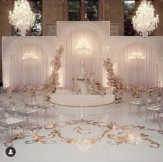 an elaborately decorated wedding ceremony room with chandeliers and flowers on the wall