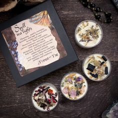 four small bowls filled with food on top of a wooden table next to a framed sign