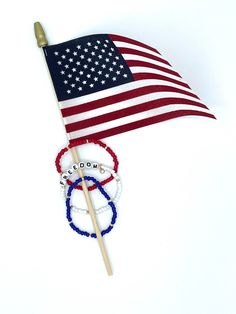 an american flag and two bracelets on top of a toothpick with beads