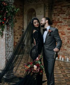 a bride and groom standing next to each other in front of an archway with flowers