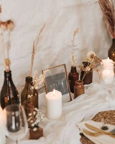 a table topped with lots of bottles and candles