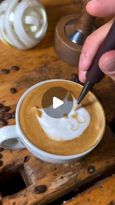 a person is painting a cup of coffee