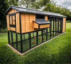 a chicken coop with chickens in the grass