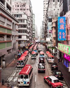 a busy city street filled with lots of traffic next to tall buildings in the distance