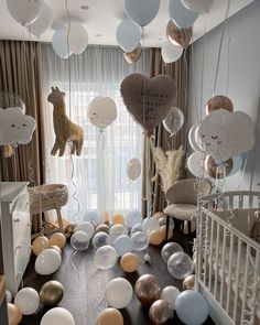 a baby's room with balloons and animals hanging from the ceiling, along with other decorations