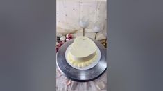 a white cake sitting on top of a silver plate