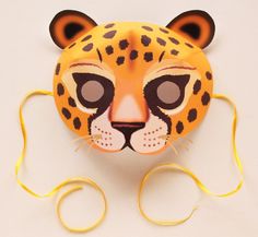 a paper mask with a leopard's face on it and yellow string attached to the mouth