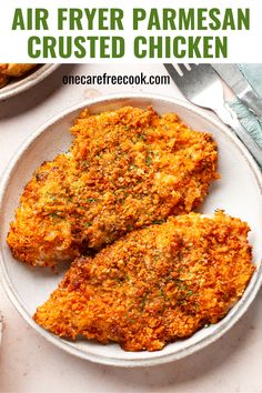 two pieces of fried parmesan chicken on a white plate with text overlay