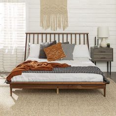 a bed with pillows and blankets on top of it in a room next to a dresser