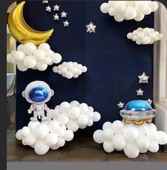 an astronaut balloon decoration with stars and moon in the sky on display at a space themed birthday party