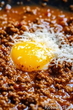 an egg on top of ground beef in a skillet