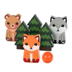 three paper animals sitting next to each other near an orange ball and some pine trees