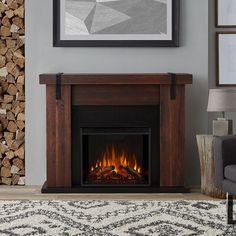 a living room with a fire place in the center and pictures on the wall above it