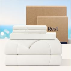 a stack of white sheets sitting next to a box