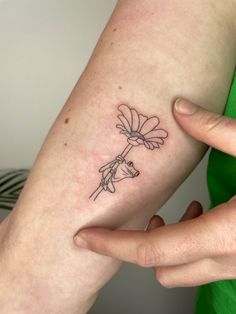 a woman's arm with a flower tattoo on the left side of her arm