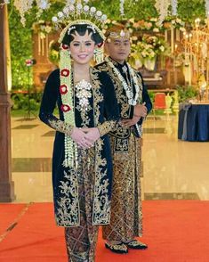 two people standing next to each other in front of a red and white carpeted floor