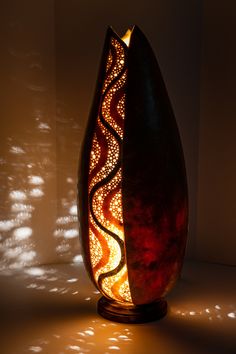 a decorative vase sitting in the middle of a room with light shining on it's side