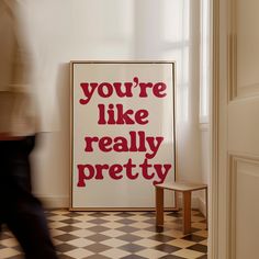 a poster that says you're like really pretty on the wall next to a chair