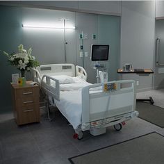 an empty hospital room with a bed and medical equipment on the ground in front of it