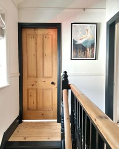 an entry way with a wooden door and black railing