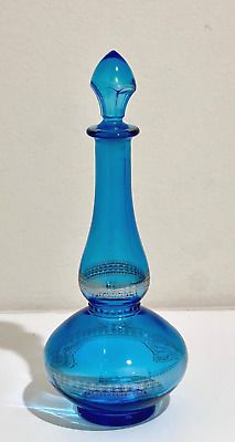 a blue glass vase sitting on top of a white table