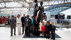 a group of people standing in front of a statue