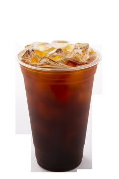 a plastic cup filled with ice cream and brown liquid on top of a white surface