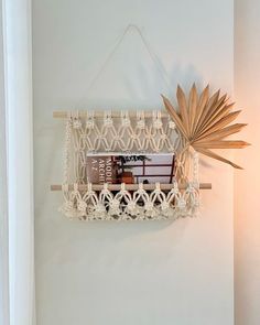 a white wall hanging with a book shelf in the middle and a sun decoration above it