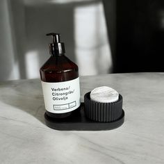 a bottle of lotion sitting next to a soap dispenser on a table