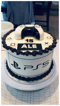 a white and black cake with a video game controller on top