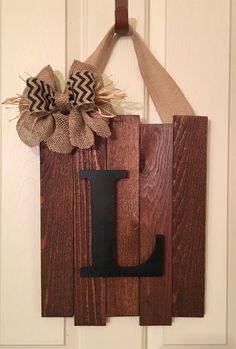 a door hanger with the letter j on it and a burluck bow