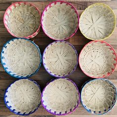 six woven baskets sitting on top of a wooden table