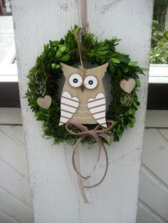 a wreath with an owl hanging on it