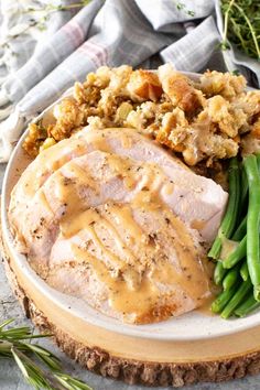 a plate with turkey, green beans and stuffing on it next to some gravy