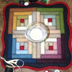 a quilted table mat with scissors, thread and other crafting supplies on it