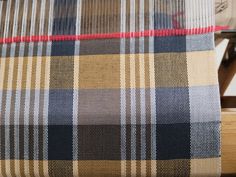 an upholstered chair with plaid fabric on it