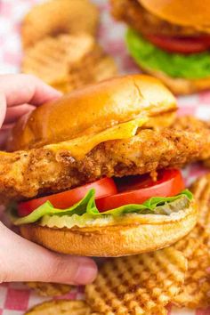 a chicken sandwich with lettuce, tomato and cheesy waffle fries