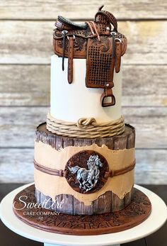 a three tiered cake is decorated with horse and saddles on the top layer