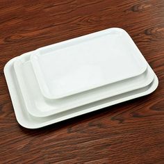 two white plates sitting on top of a wooden table