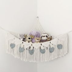 stuffed animals in a hammock hanging on the wall