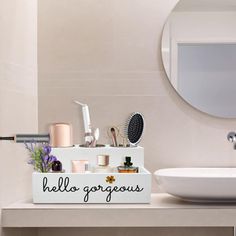 a white sink sitting under a bathroom mirror next to a counter with various items on it