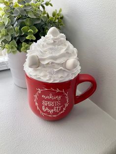 a red coffee cup filled with whipped cream