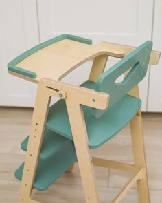 a wooden chair with green seats on the floor