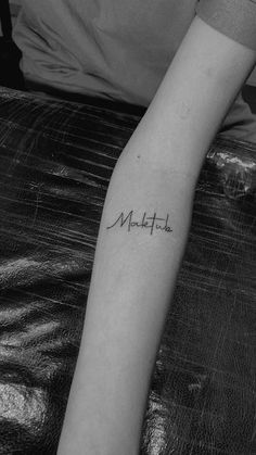 a person with a tattoo on their arm that says make it written in cursive writing