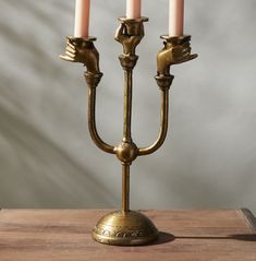 a brass candelabra with three candles on it