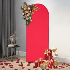 a room with red and gold decorations, flowers and gifts on the floor next to it